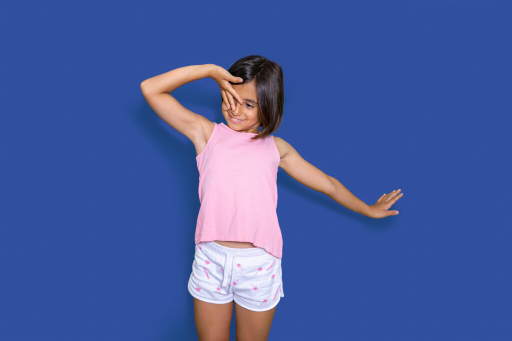 Niña pequeña tapándose un ojo con la mano, expresando vergüenza o inseguridad ante una situación donde no quiere decir la verdad.